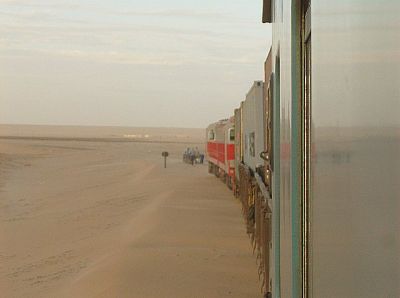 Schmalspur in Namibia
Zwei chinesische Neubaumaschinen bespannen den Zug Walvis Bay - Otjiwarongo in der Namib-Wüste. Nach einem Sandsturm wird das Gleis freigeschaufelt.
